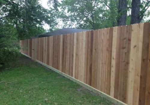 Front side of residential fencing with alternating colors of wood