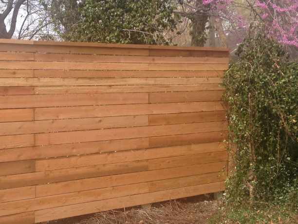 Cedar privacy fence with a finished top cap along a property line