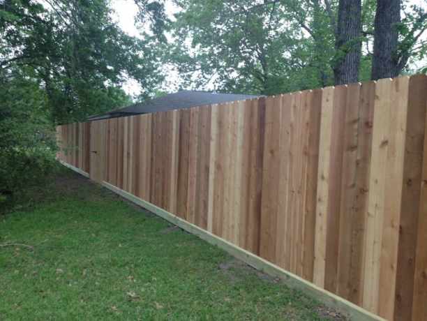 Privacy fence across the back of a wooded lawn