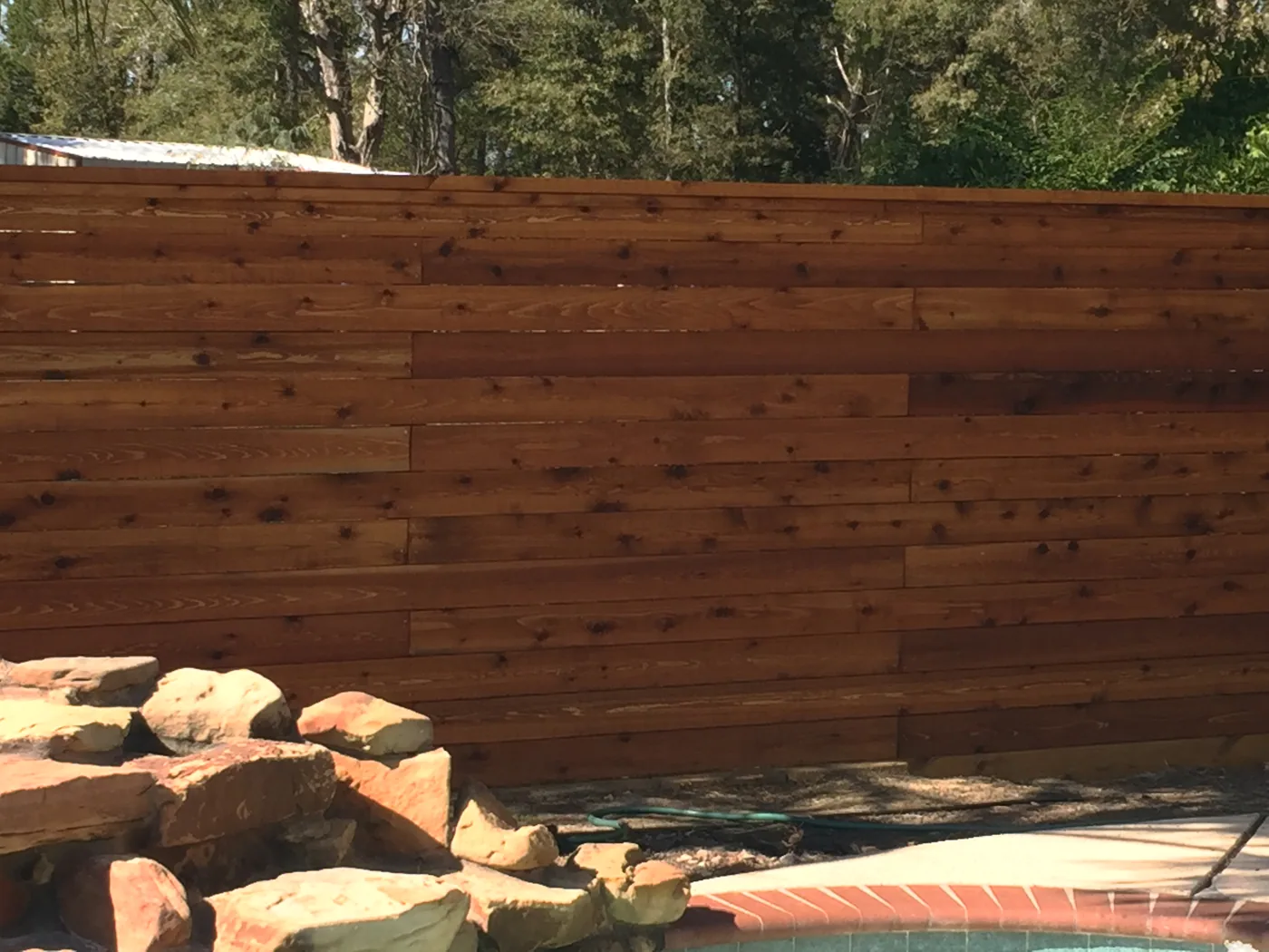 Horizontal fence boards above a stone waterfall