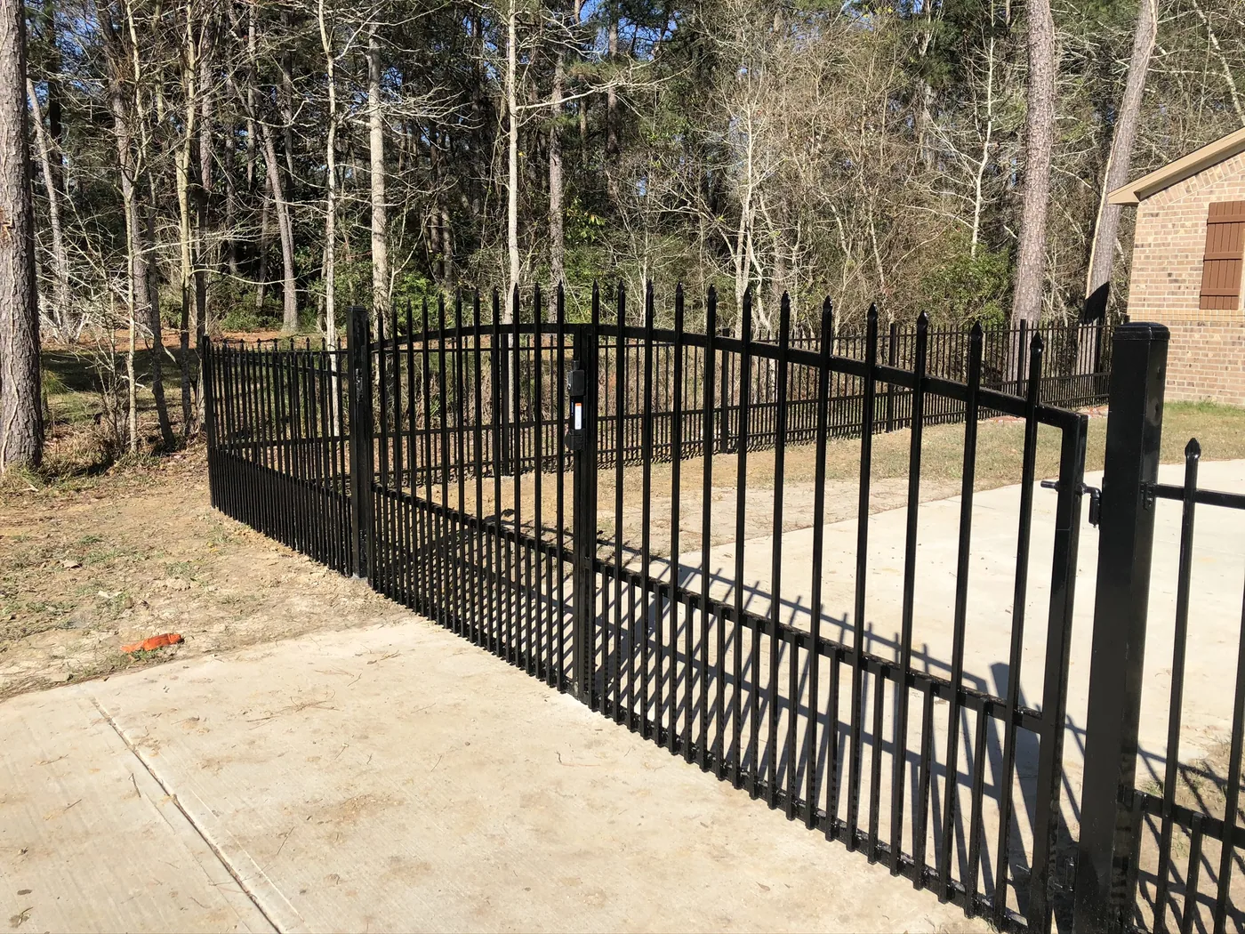 Wrought iron double driveway gate at a brick home