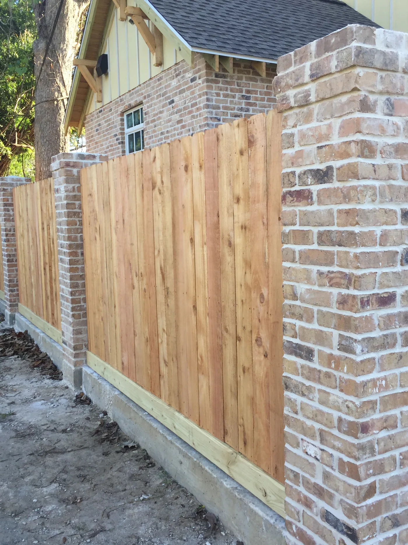 Cedar fence panels between brick columns