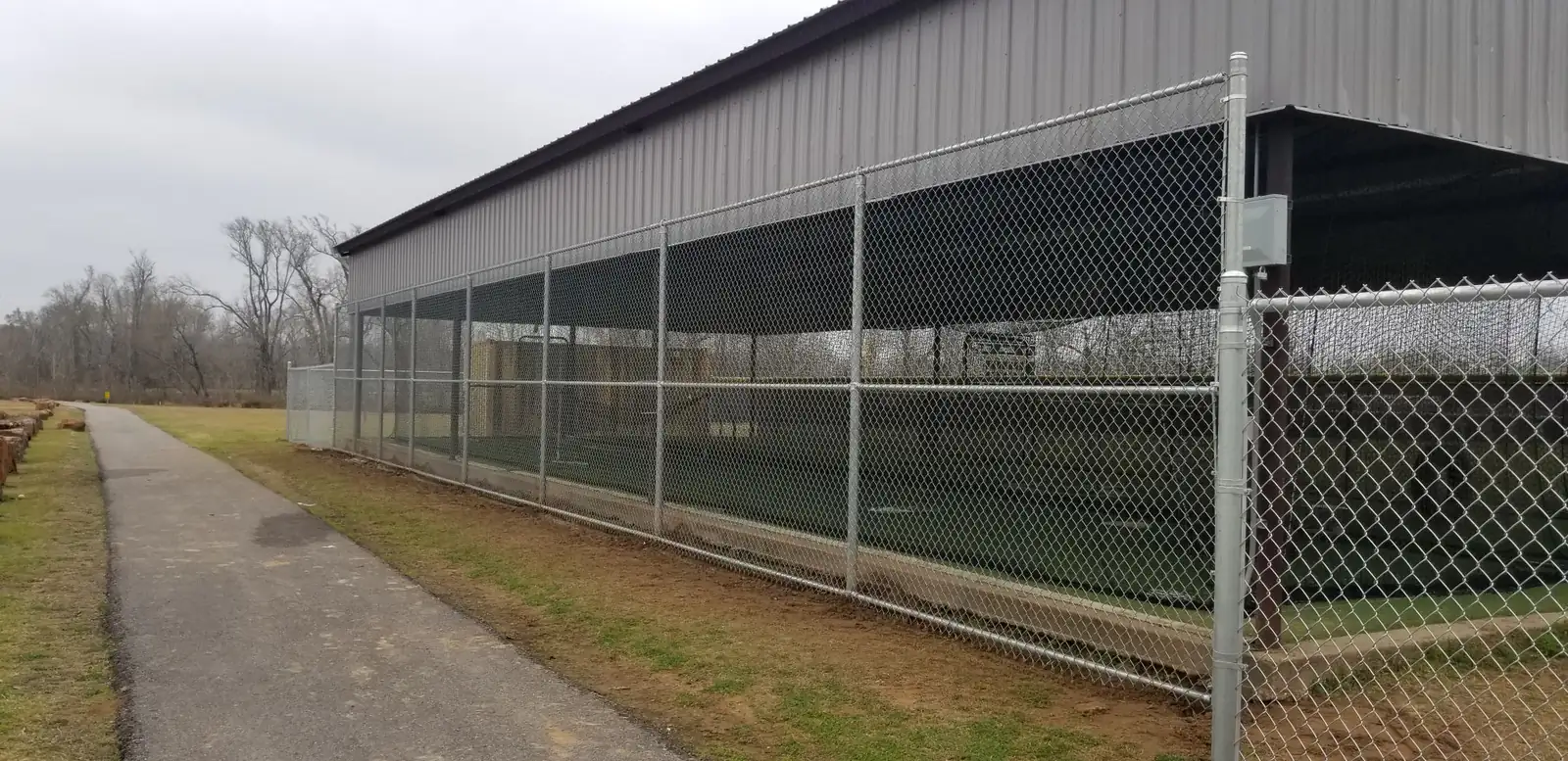 Commercial chain link fencing along the side of a metal building