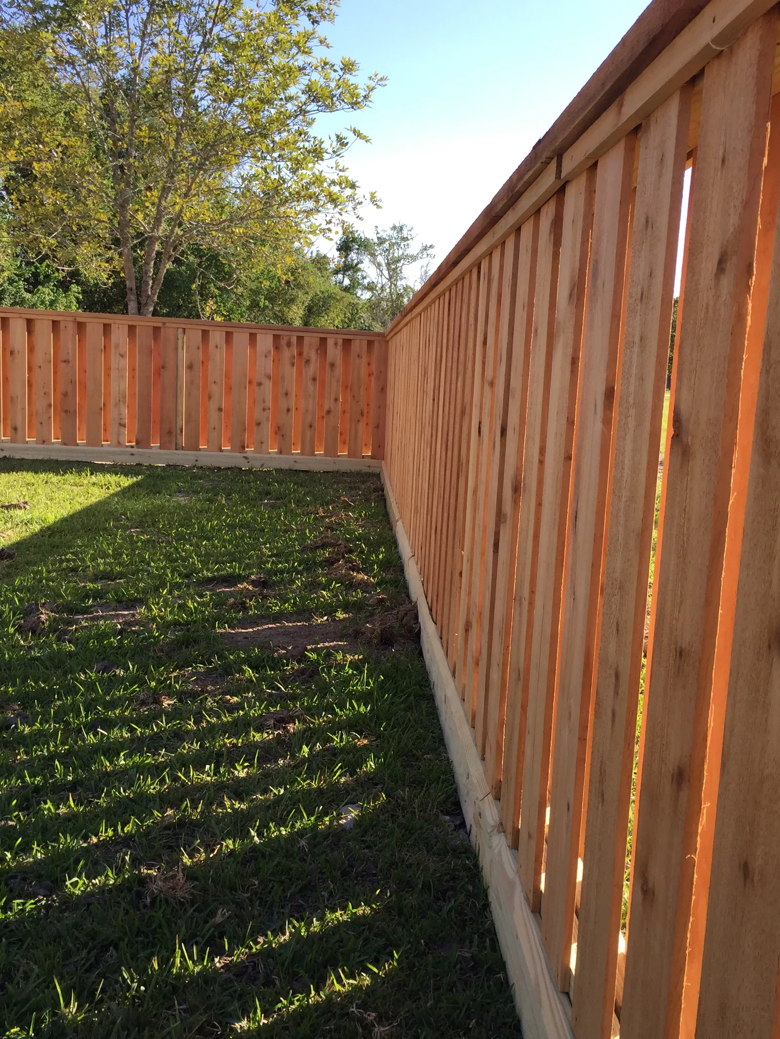 Cedar privacy fence turning a corner in a back lawn
