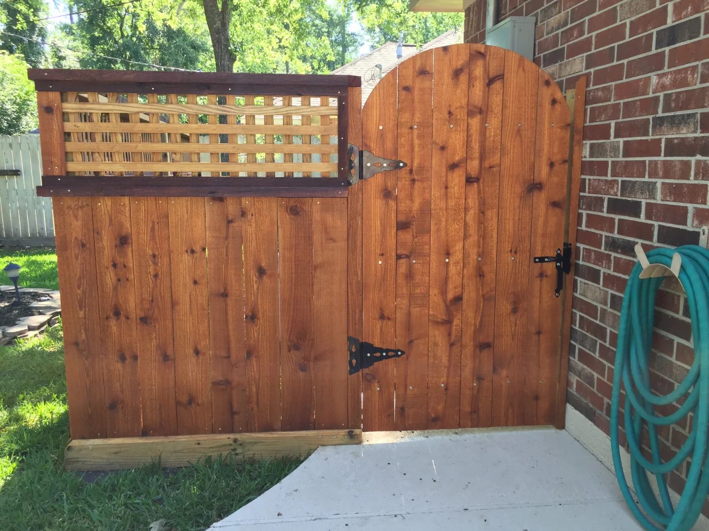 Arched cedar walk-through gate with a lattice top panel
