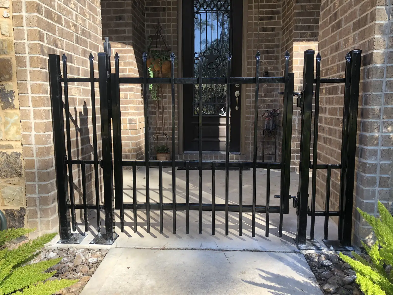 Wrought iron gate enclosing a brick entry courtyard
