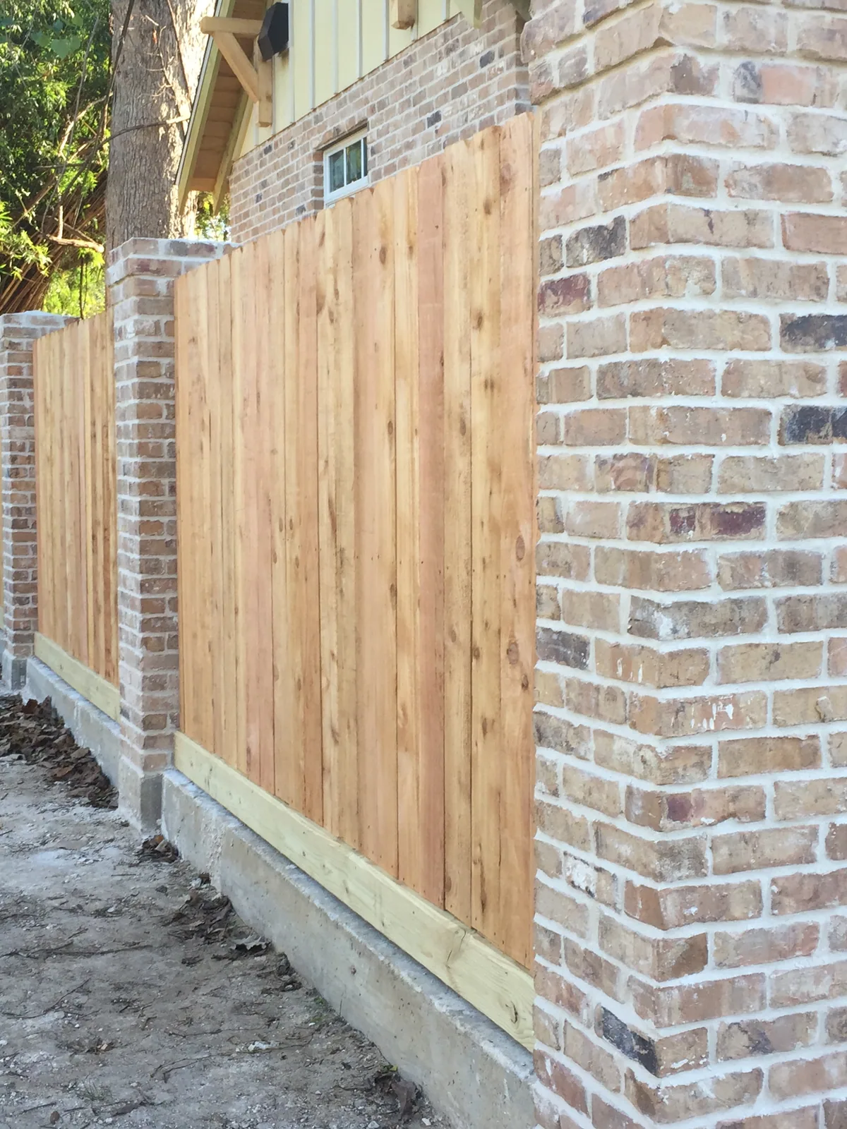 Cedar fence panels set between brick columns